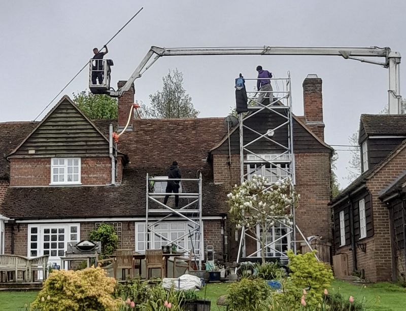 The Roof Moss Cleaners using cherry picker and scaffolding to clean roof safely and professionally in Oxted, Surrey